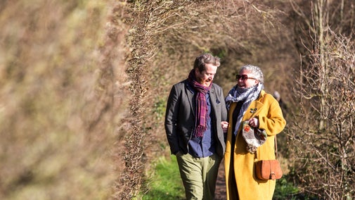Couple walking along a woodland path at Speke Hall, Liverpool